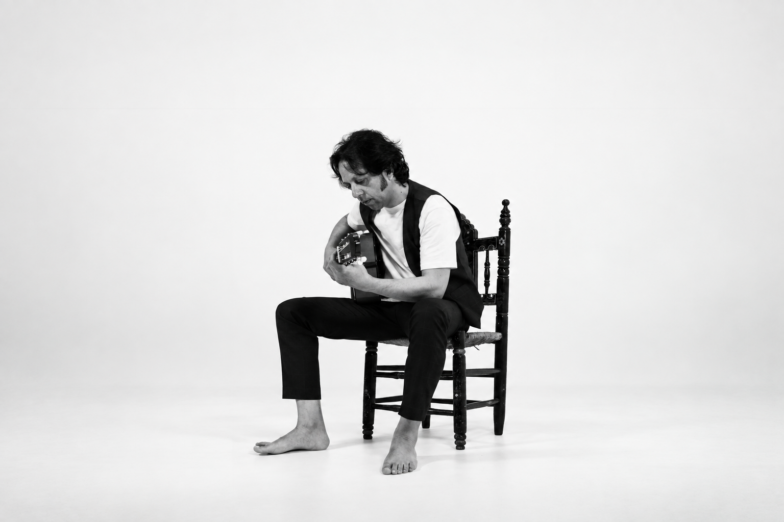 Jesús Carbonell tocando la guitarra en una sesión fotográfica en blanco y negro